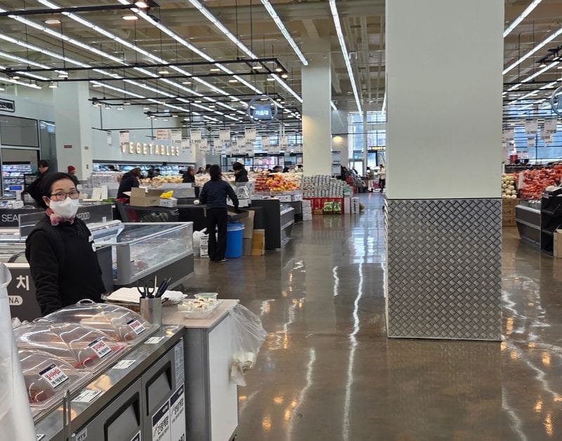 Wide, spacious interior aisles of Easy Buy Supermarket Bongdam with fresh produce section.