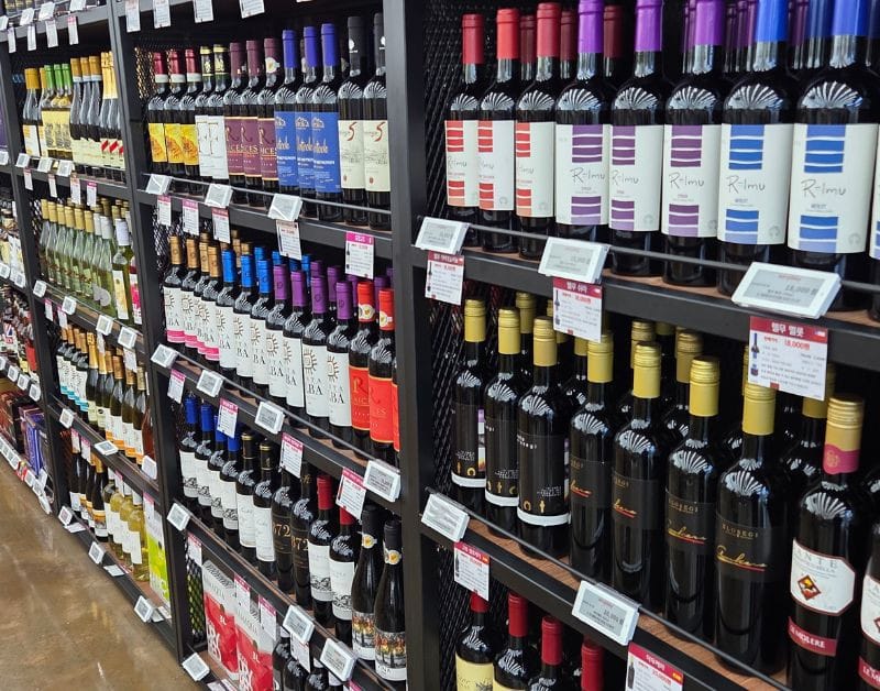 Shelves stocked with various imported red wines at Easy Buy Supermarket.