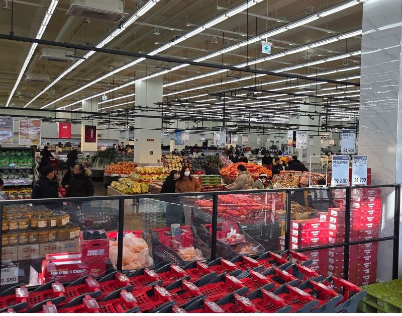Wide interior view of Easy Buy Supermarket showing the fresh produce section and high ceilings.