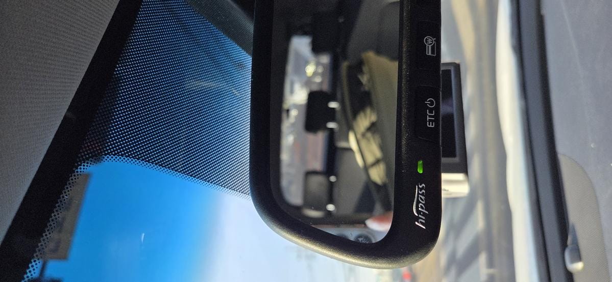 A blue Hi-Pass card is installed in the car rear view mirror hipass slot.