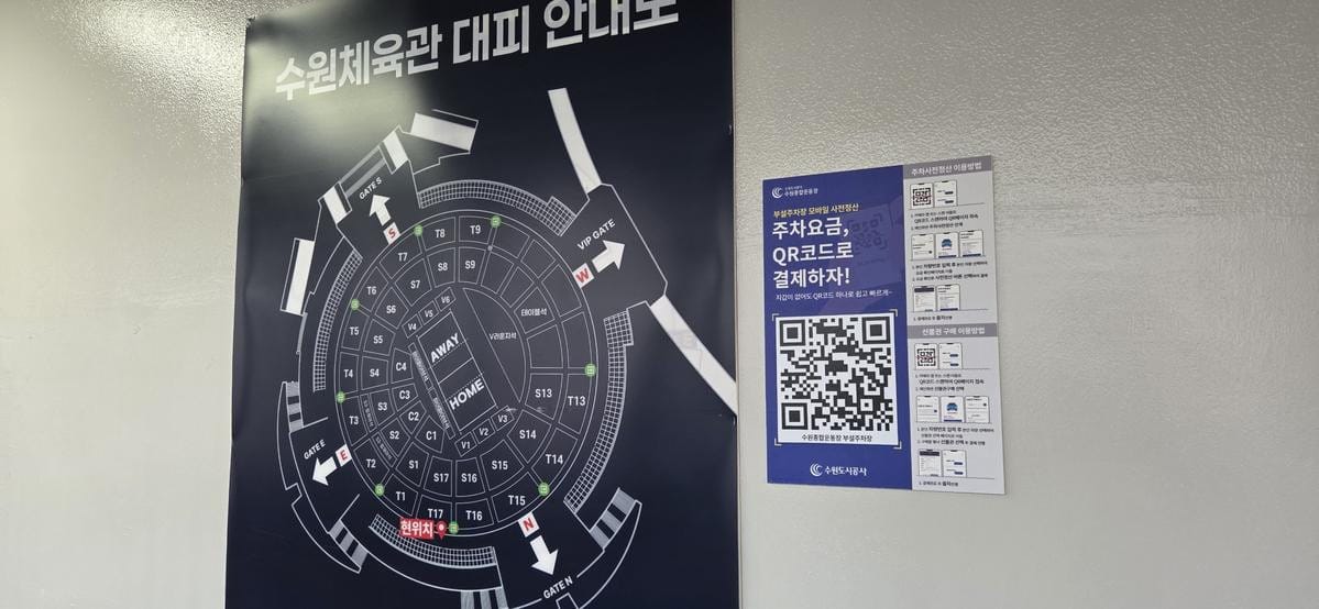 壁の看板に、緊急避難マップと駐車料金の事前精算用QRコードが表示されている。
