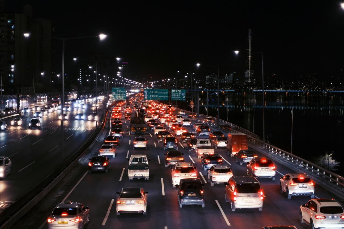 Long exposure of car tail lights creating red streaks on a busy multi-lane highway at night.
