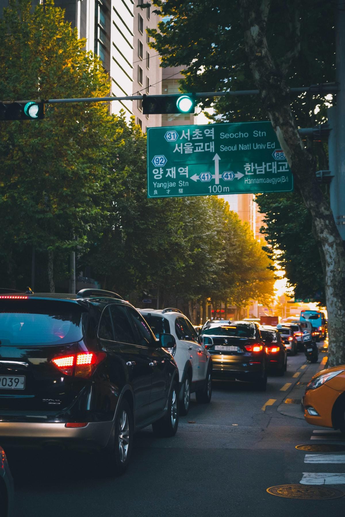 Numerous silver and white cars packed closely together in heavy traffic on a grey asphalt road.