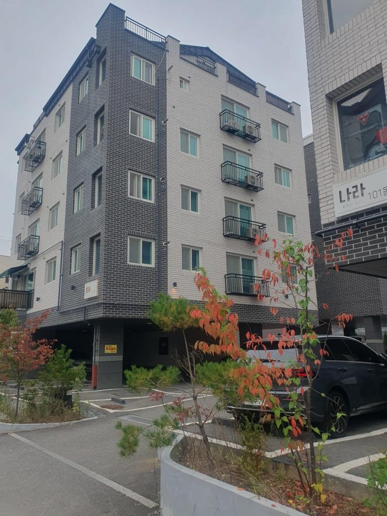 非常に狭く窮屈なスペースに車両が押し込まれた、薄暗い屋内駐車場。
