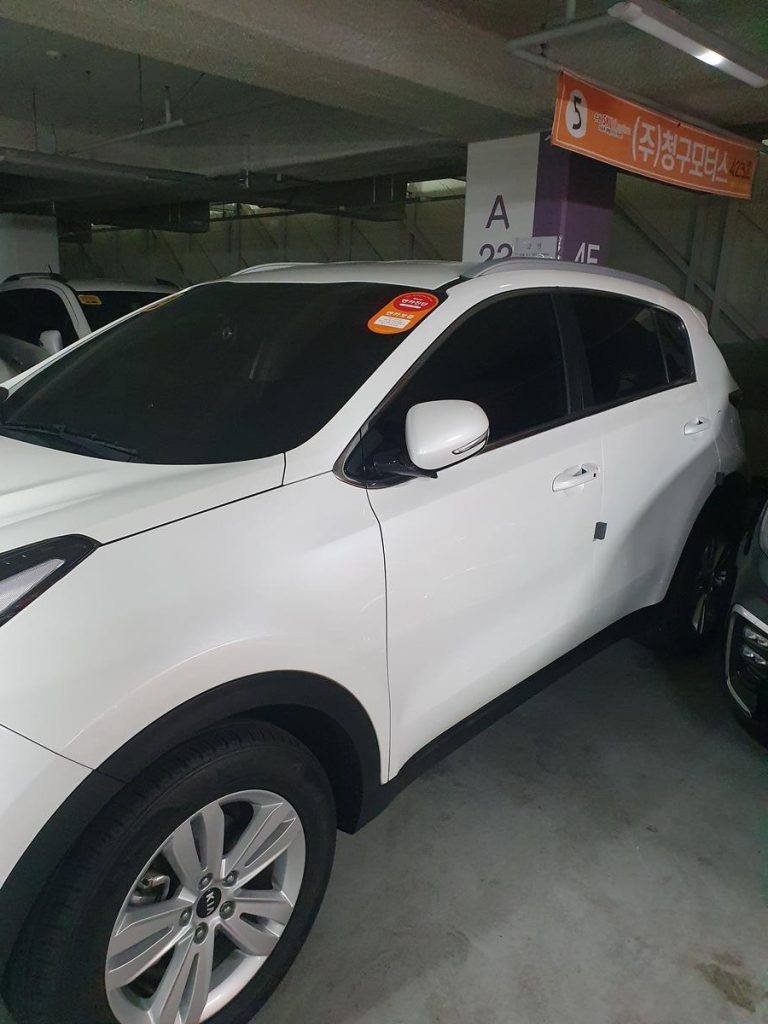 Exterior side profile view of a passenger vehicle parked on a paved surface.