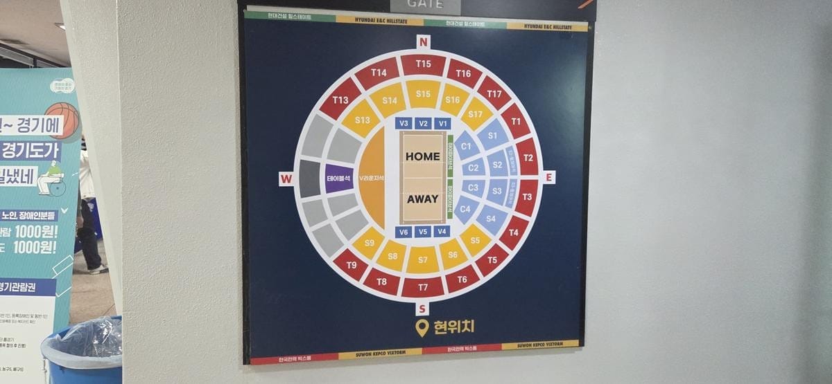 A wall-mounted display shows a color-coded seating map of the stadium.