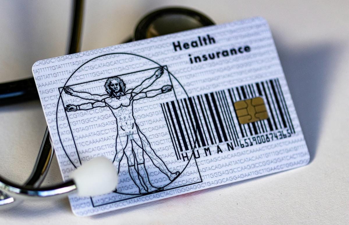 A person holds a health insurance card.