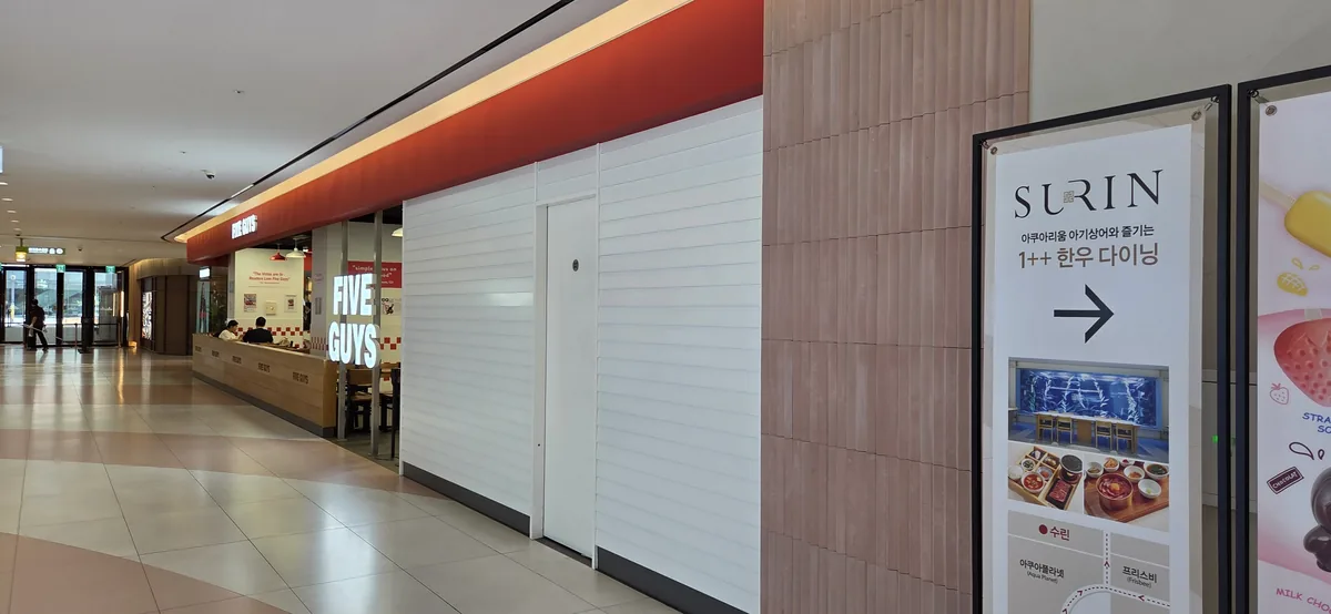 The Five Guys burger restaurant sign, an excellent Aquaplanet Gwanggyo food option.