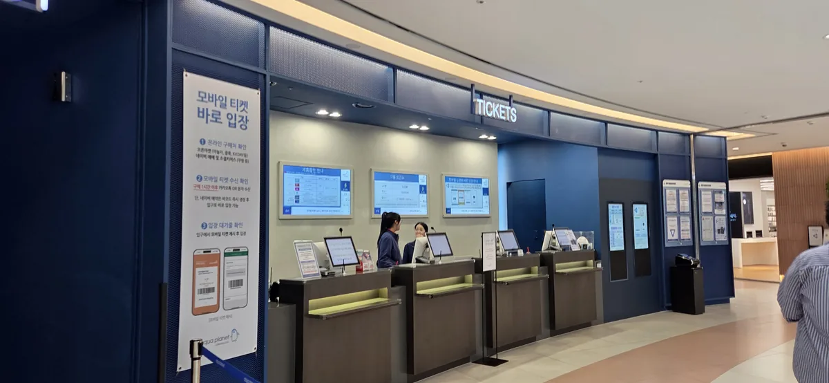 The ticketing counter for entry, surrounded by potential Aquaplanet Gwanggyo food options.
