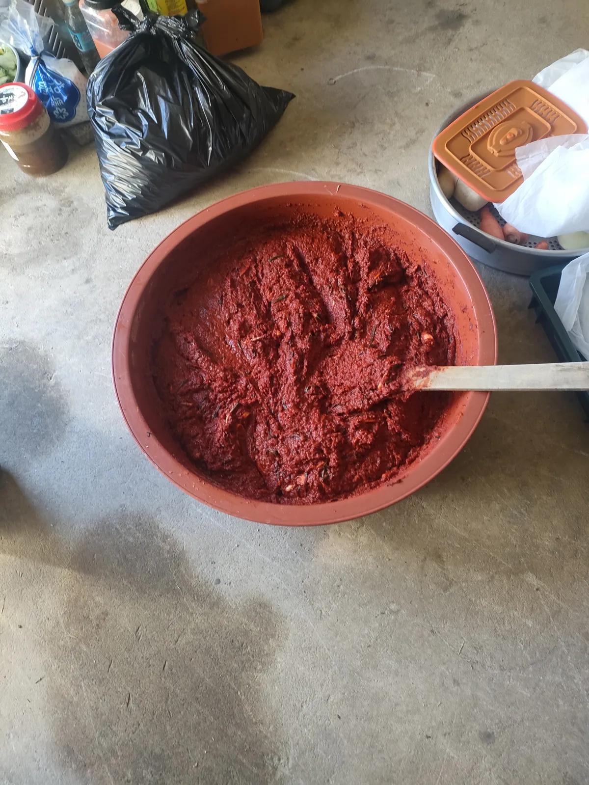 A massive red tub of spicy kimchi seasoning paste for a kimjang kimchi family tradition expat korea.
