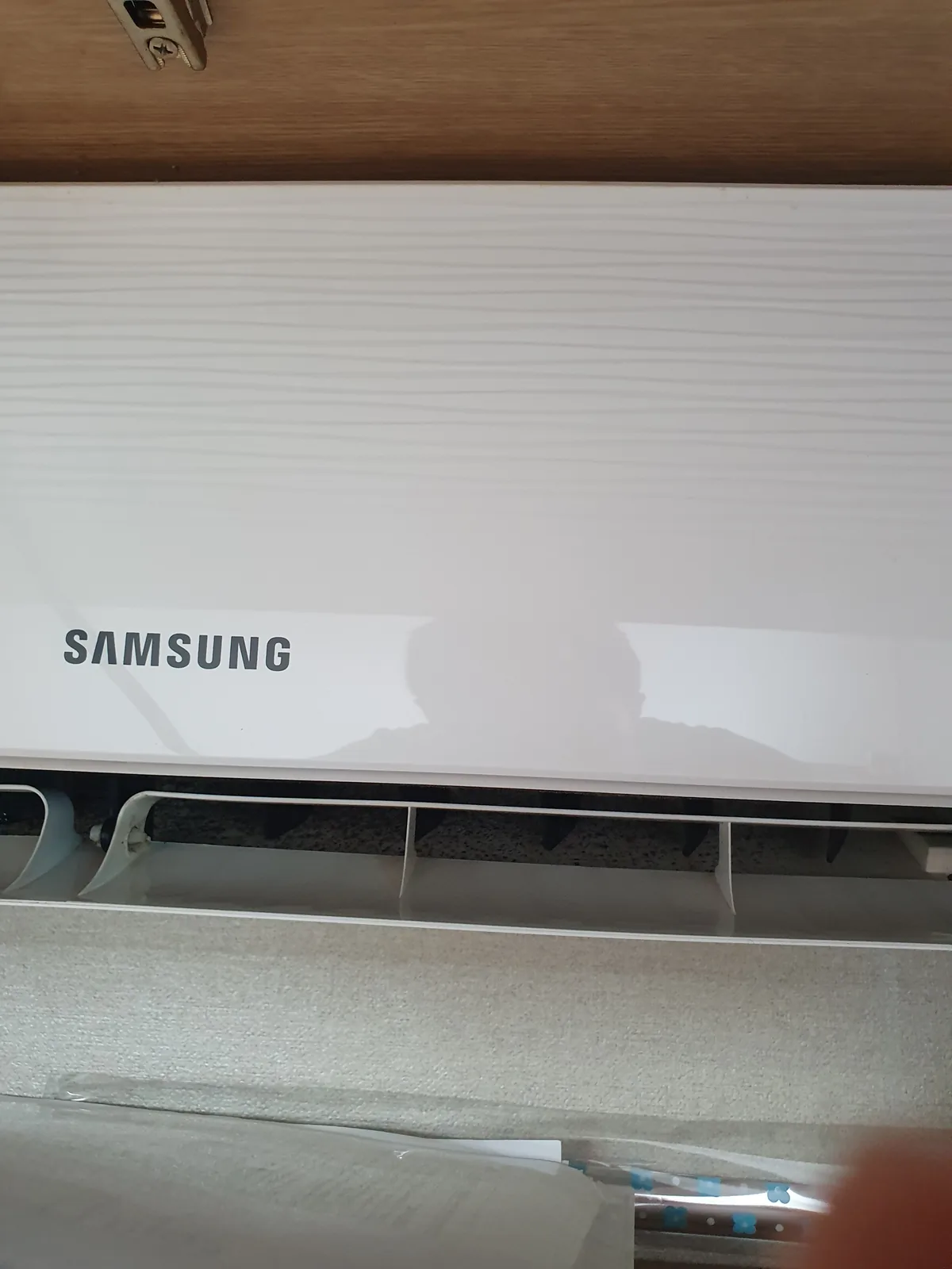 Samsung air conditioner mounted on wall with visible mould or discolouration around the vents, photographed on move-in day.