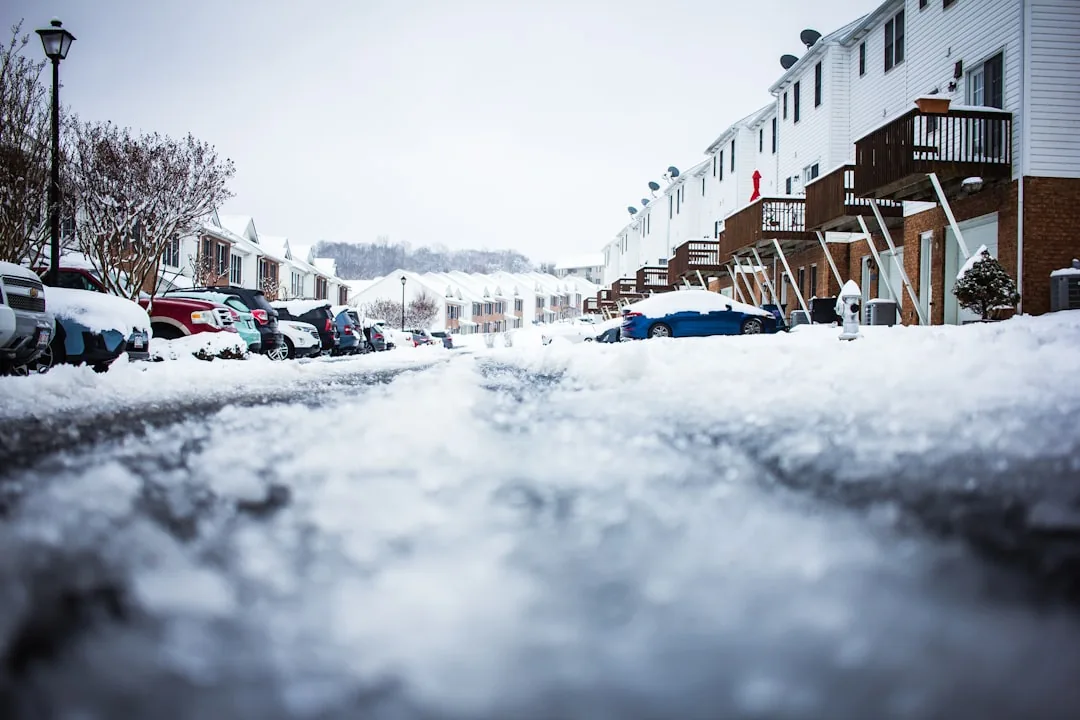 Vehicles stopped at a traffic light on a slushy city street.