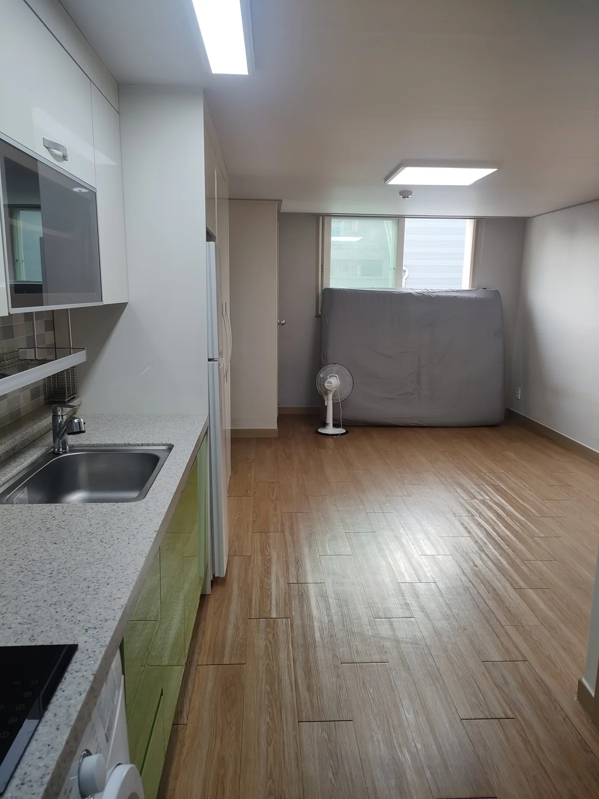 Full interior view of a Korean one-room officetel showing kitchen and living area on move-in day.