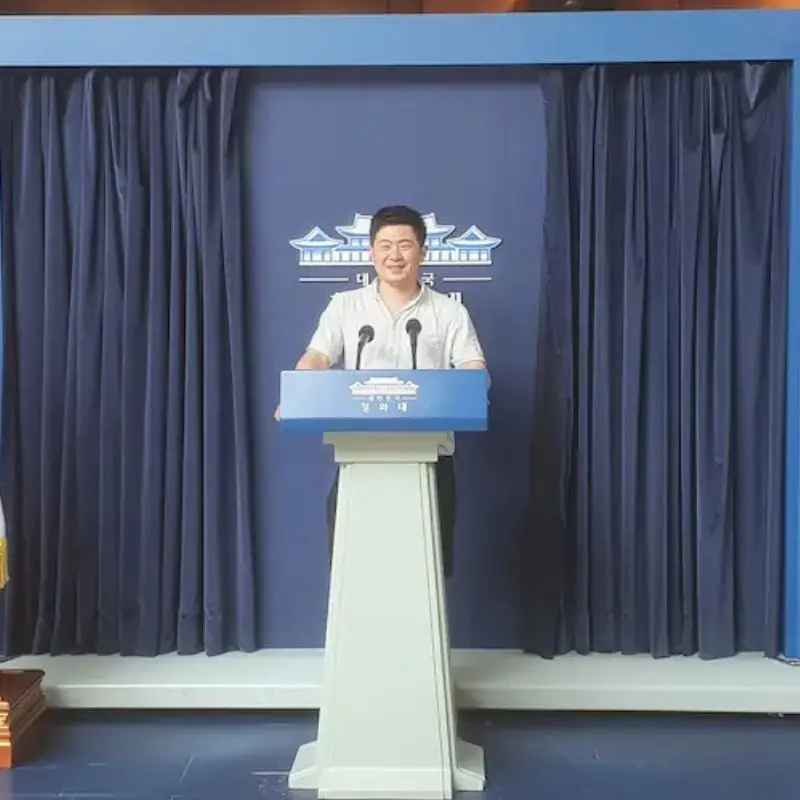 Jin standing at the spokesperson's podium of the Blue House in Seoul