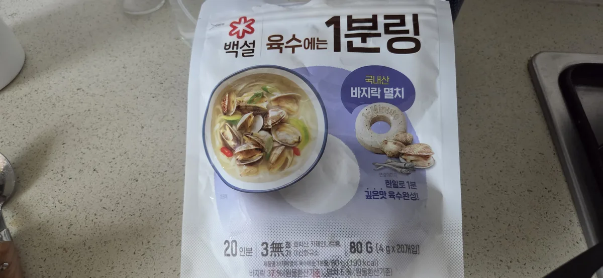 韓国の即席アワビわかめスープのパッケージ。表面にはハマグリと出汁、裏面には乾燥した貝が描かれている