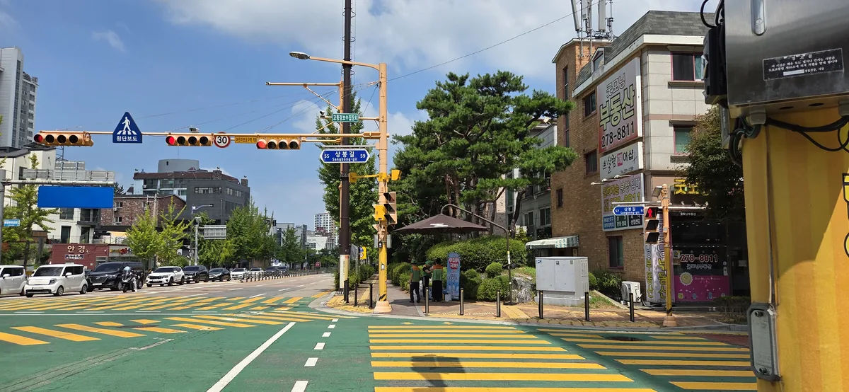 Open parasol set up beside a Korean pedestrian crossing