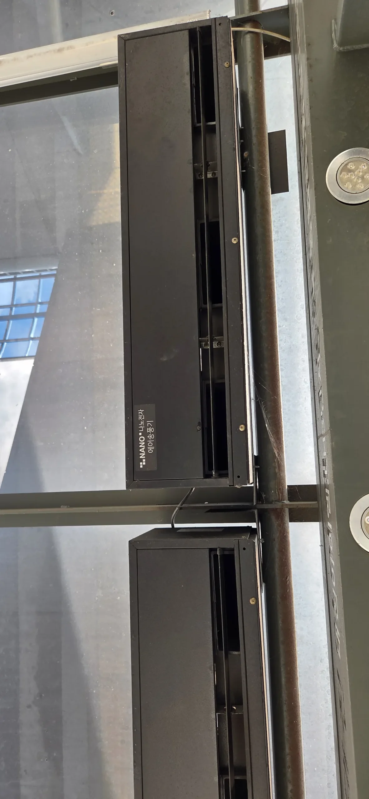Wall-mounted cold-air blower with two round vents at a Korean bus stop