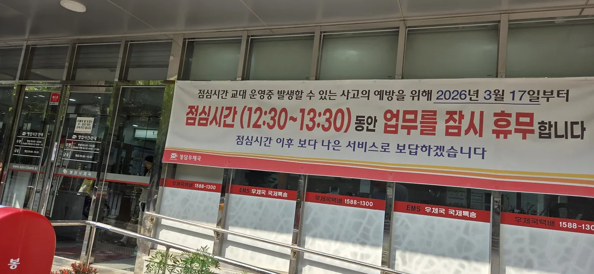 Banner across the post office entrance announcing that all counters close for lunch between 12:30 and 13:30.