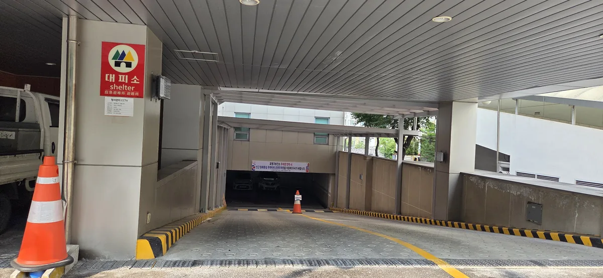 Ramp down to the health center's underground car park, with an overflow parking notice at the far end.